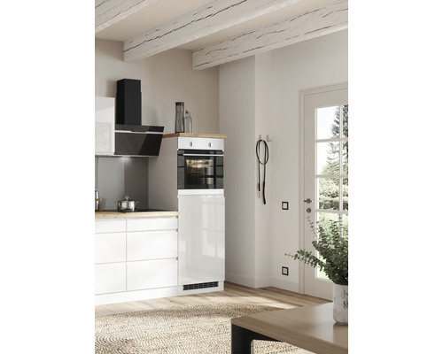 Cuisine claire avec four intégré, hotte aspirante et plafond à poutres apparentes.