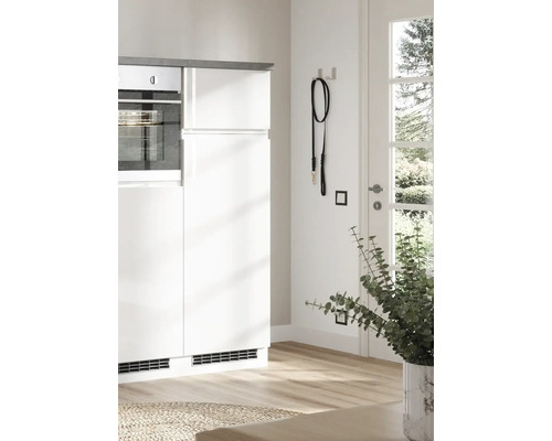 Scène de cuisine avec des armoires blanches, un four, une laisse noire pour chien et une plante d''intérieur