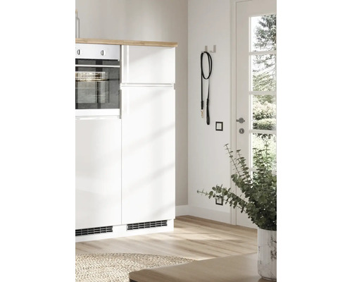 Scène de cuisine avec armoires blanches, four et laisse pour chien au mur