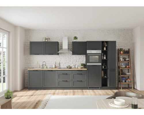 Moderne Küche mit grauen Schränken, Arbeitsplatte aus Holz und Edelstahlgeräten vor einer Wand mit Ziegelmuster.