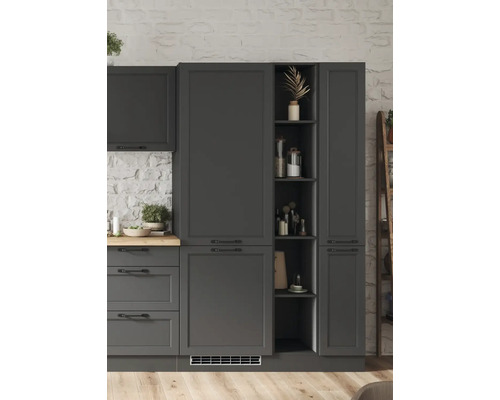 Armoires de cuisine gris foncé avec étagères et tiroirs devant un mur de pierre blanc.