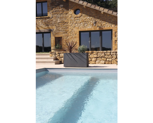 Steinhaus mit Pool und bepflanztem Pflanzkasten im Garten.