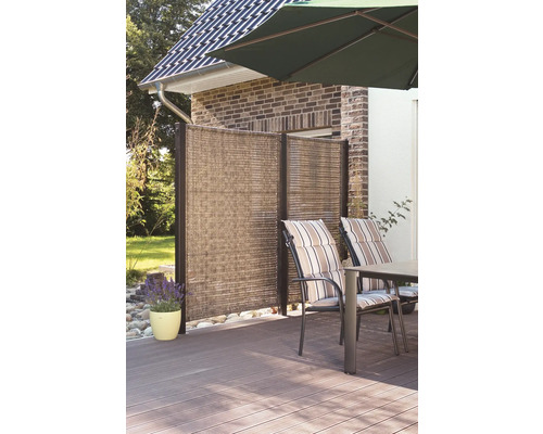 Terrasse avec paravent, table de jardin et chaises sous un parasol