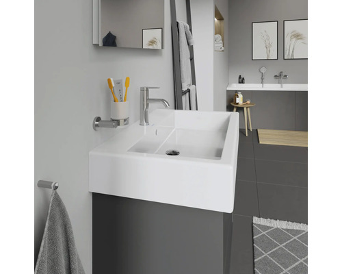 Modernes Badezimmer mit Waschbecken, Armatur, Spiegel und Handtuchhalter.