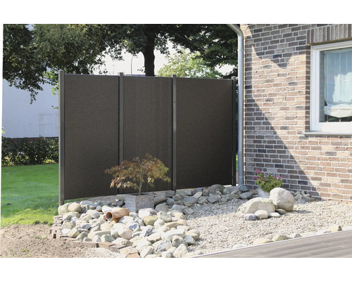 Gartenszene mit Sichtschutzzaun, Steinen und Pflanze