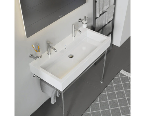 Lavabo blanc avec cadre chromé et robinetterie dans la salle de bain