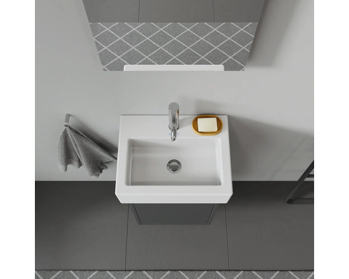 Aufnahme von oben eines Badezimmers mit Waschtisch, Armatur, Seifenschale und Handtuchhalter