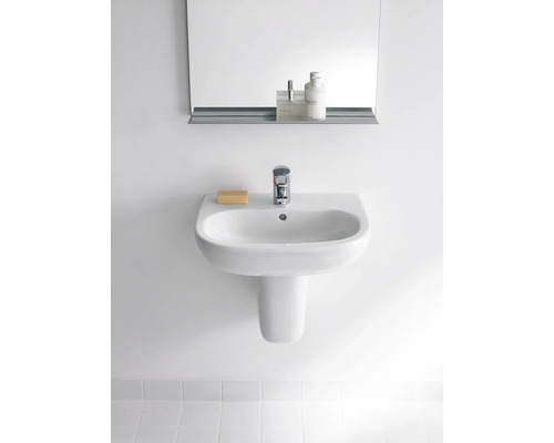 Lavabo en céramique blanche avec robinet, savon et miroir au mur