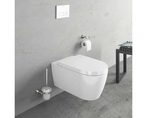 WC suspendu avec brosse de toilette et plaque de commande devant un mur gris