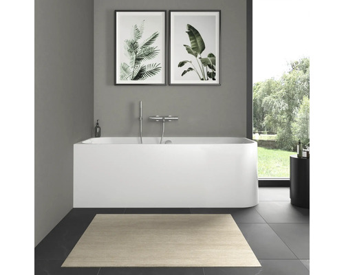 Salle de bains avec baignoire, robinetterie, tapis et décorations murales