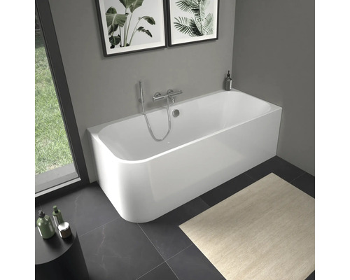 Baignoire blanche avec robinetterie dans salle de bain