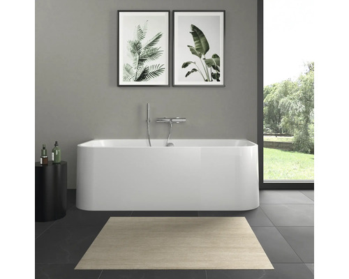 Salle de bain avec baignoire îlot, tapis et tableaux de plantes