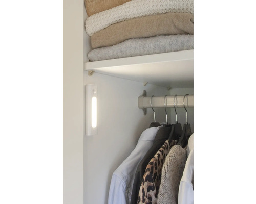 Vue intérieure d''une armoire avec des vêtements, une étagère et une lampe LED.