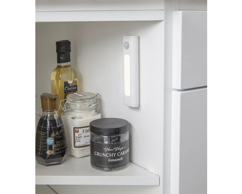 Photo d''intérieur d''une étagère blanche avec divers aliments et une lampe LED avec détecteur de mouvement