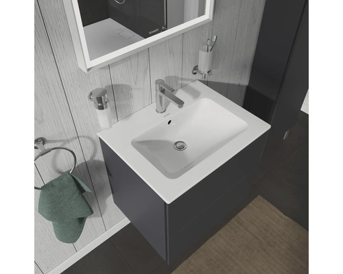 Meuble-lavabo avec meuble bas, robinetterie et accessoires de salle de bain dans une salle de bain lumineuse.