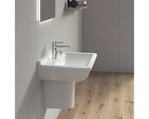 Modernes Badezimmer mit einem weißen Waschbecken und Armatur an einer Betonwand.