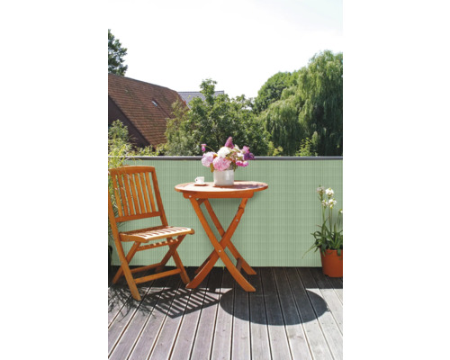 Scène de balcon avec écran d''intimité, table en bois, chaise et fleurs