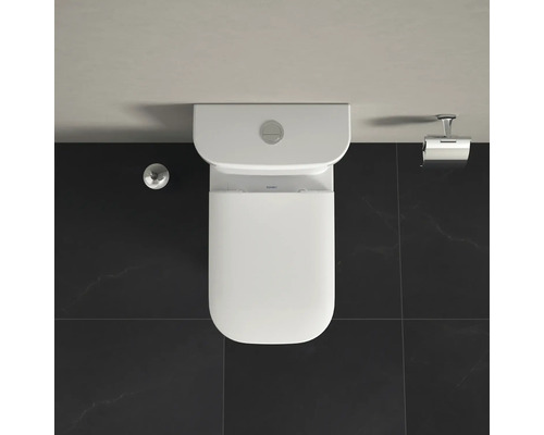 Vue de dessus d''un WC sur pied blanc avec réservoir, porte-papier toilette et bouton de chasse d''eau