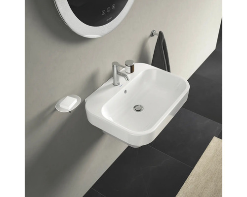 Salle de bains lumineuse avec lavabo, distributeur de savon, miroir et porte-serviettes.