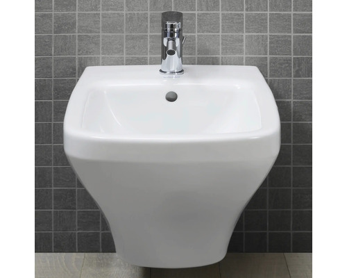 Weisses Wandwaschbecken mit Chromarmatur vor grauer Fliesenwand