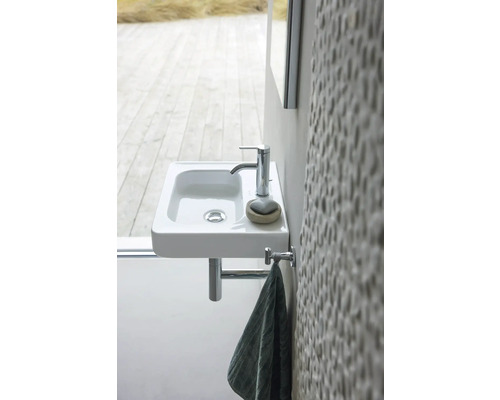 Kleines Waschbecken mit Armatur und Handtuchhalter im Badezimmer.