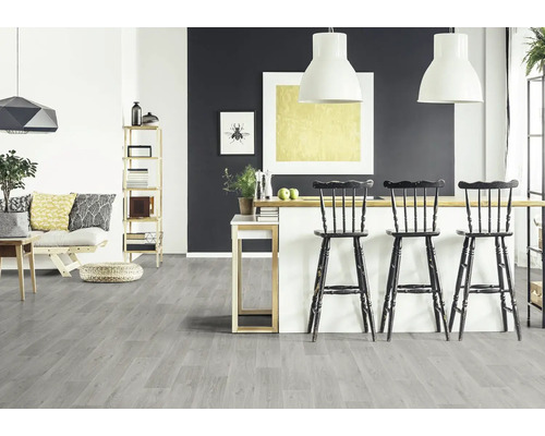 Salon lumineux avec canapé, étagère, table à manger et sol en vinyle gris