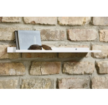 Weisses Wandregal mit Buch und Sonnenbrille an einer Ziegelwand