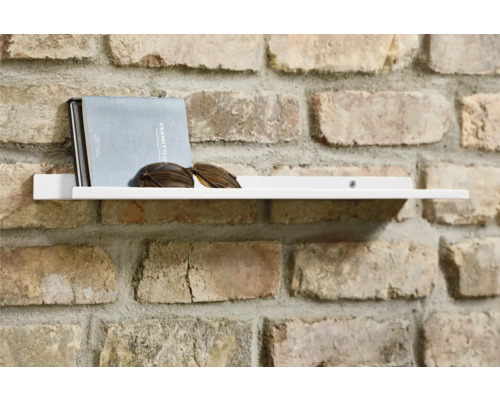 Weisses Wandregal mit Buch und Sonnenbrille an einer Ziegelwand