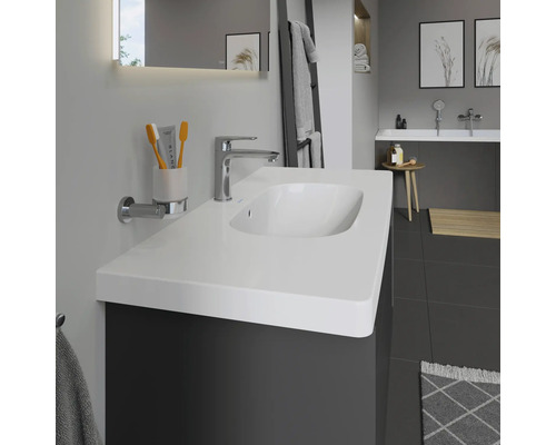 Salle de bain avec lavabo, robinet, miroir et accessoires dans un design moderne