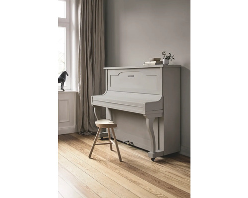 Piano gris avec tabouret dans une pièce lumineuse.