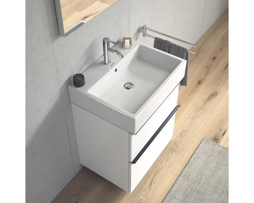 Meuble-lavabo blanc avec meuble sous-vasque, robinetterie et porte-serviettes dans la salle de bains
