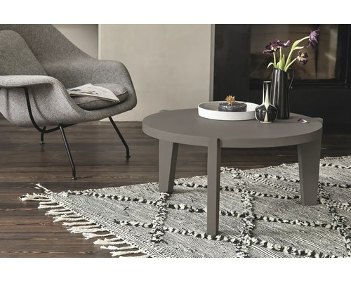 Wohnzimmer mit Sessel, Couchtisch und gemustertem Teppich