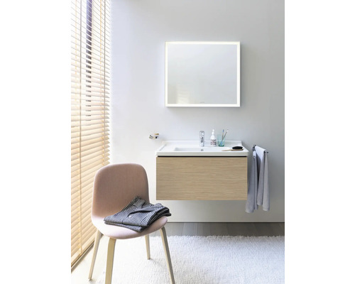 Salle de bain lumineuse avec lavabo, meuble sous-lavabo, miroir avec éclairage et chaise