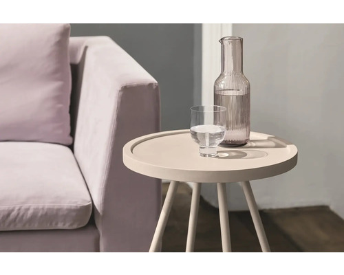 Scène d''aménagement intérieur avec canapé, verre à eau et carafe à eau sur une table d''appoint.