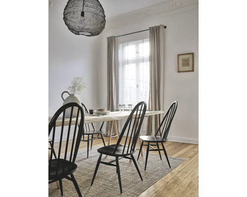 Salle à manger lumineuse avec table en bois, chaises à barreaux, tapis et plafonnier