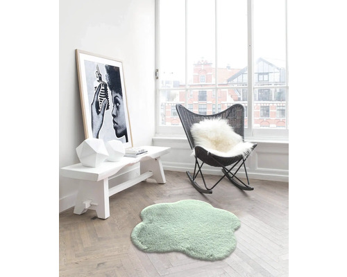 Pièce lumineuse avec petit tapis, banc, décoration et fauteuil à bascule