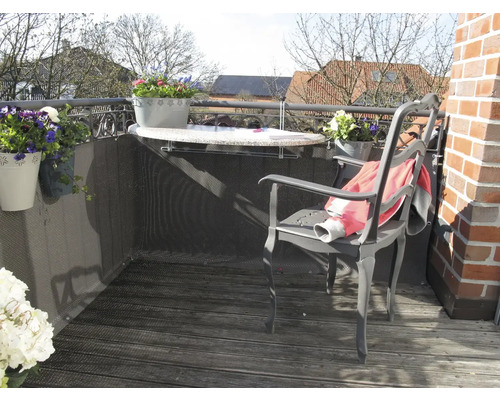 Balkonszene mit Tisch, Stuhl, Sichtschutz und bepflanzten Blumenkästen