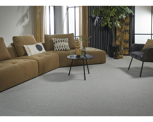 Wohnzimmer mit großem Sofa, Sessel, Tisch und Teppich