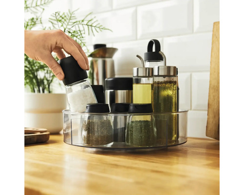 Présentoir à épices rotatif avec des épices et des bouteilles d''huile sur un comptoir de cuisine.