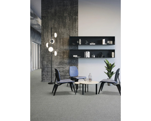 Szene mit Sitzgruppe, bestehend aus drei Stühlen und einem runden Tisch, ergänzt durch Regale und eine Stehlampe