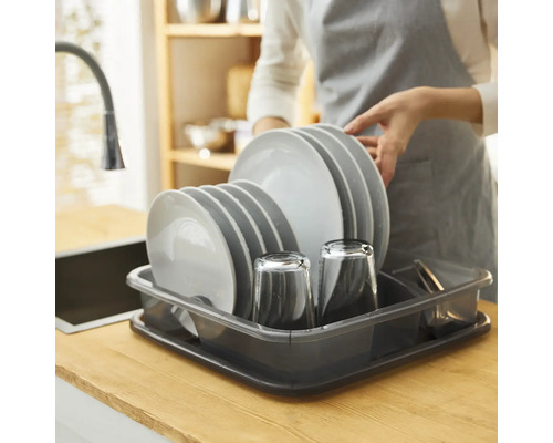 Abwasch mit Tellern und Gläsern in einem Abtropfgestell auf einer Küchentheke