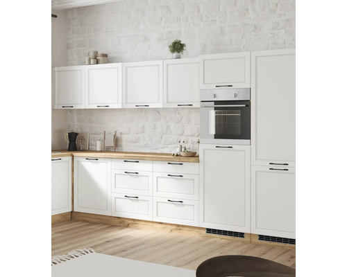 Cuisine de campagne lumineuse avec des armoires blanches, un plan de travail en bois et un four