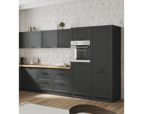 Küchenzeile mit Unterschränken, Hängeschränken und Einbaubackofen vor einer weissen Ziegelwand