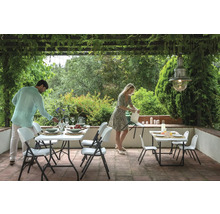 Terrasse mit Gartentischen und Klappstühlen für eine Mahlzeit im Freien