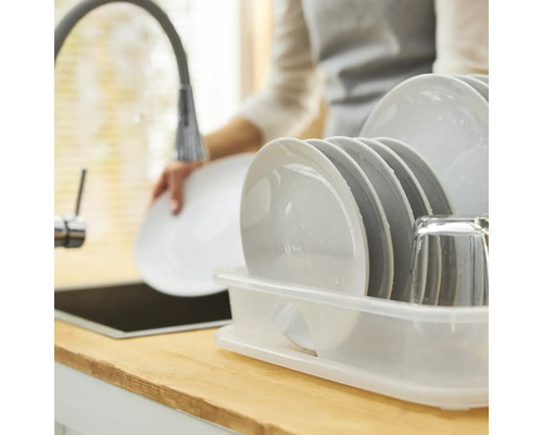 Geschirrablage mit Tellern und Glas auf einer Küchentheke neben einer Spüle