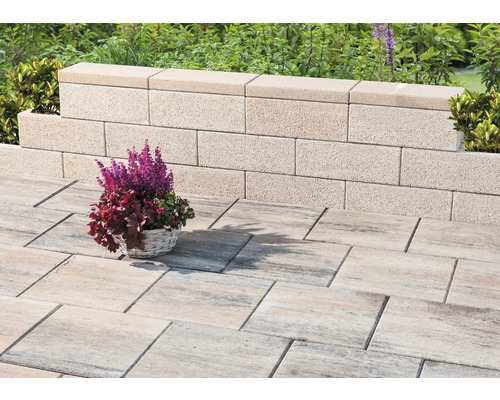 Mur de jardin en béton avec pavés et panier de fleurs
