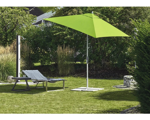 Parasol carré, chaise longue et douche de jardin sur une pelouse