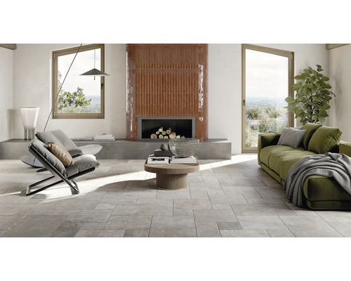 Heller Wohnraum mit Fliesenboden, Kamin, Sofa und Sessel