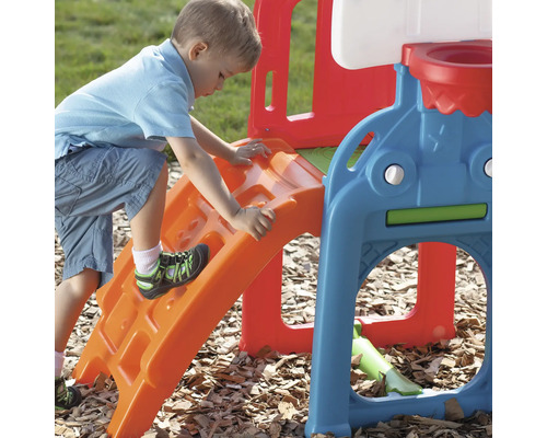 Garçon escalade une aire de jeux avec toboggan et panier de basket