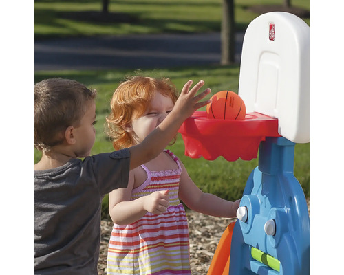 Des enfants jouent avec un panier de basket à l''extérieur